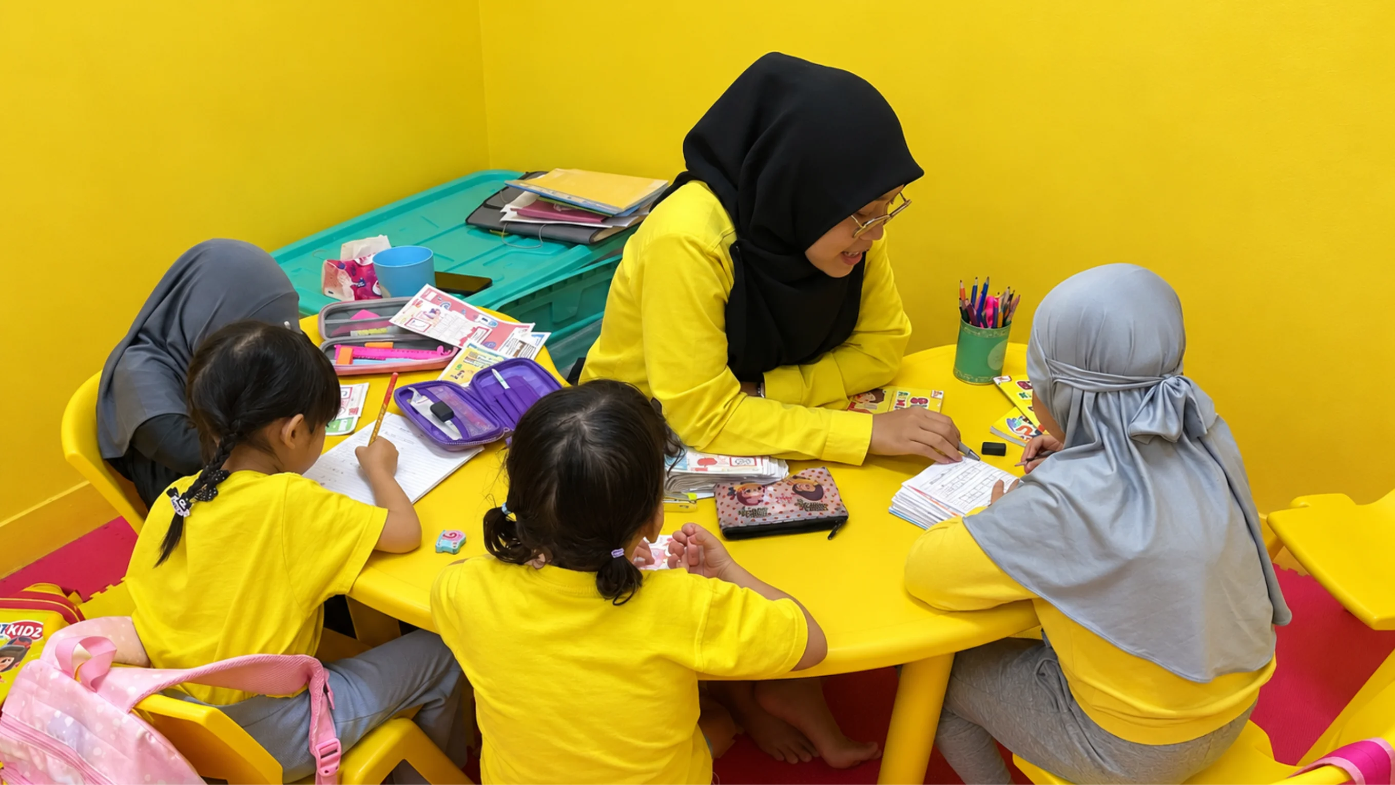 Guru Smartkidz mendampingi anak-anak belajar membaca dan menulis bersama di kelas bimbel.